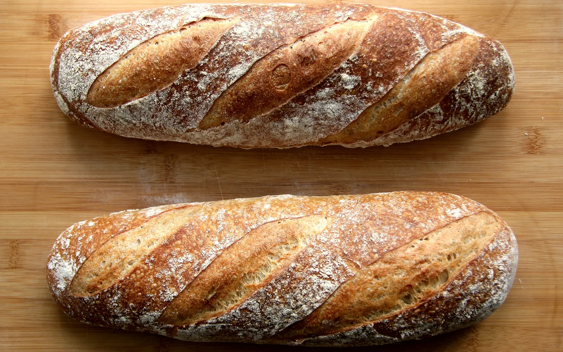 Deux pains de campagne grignés, tout juste sortis du four